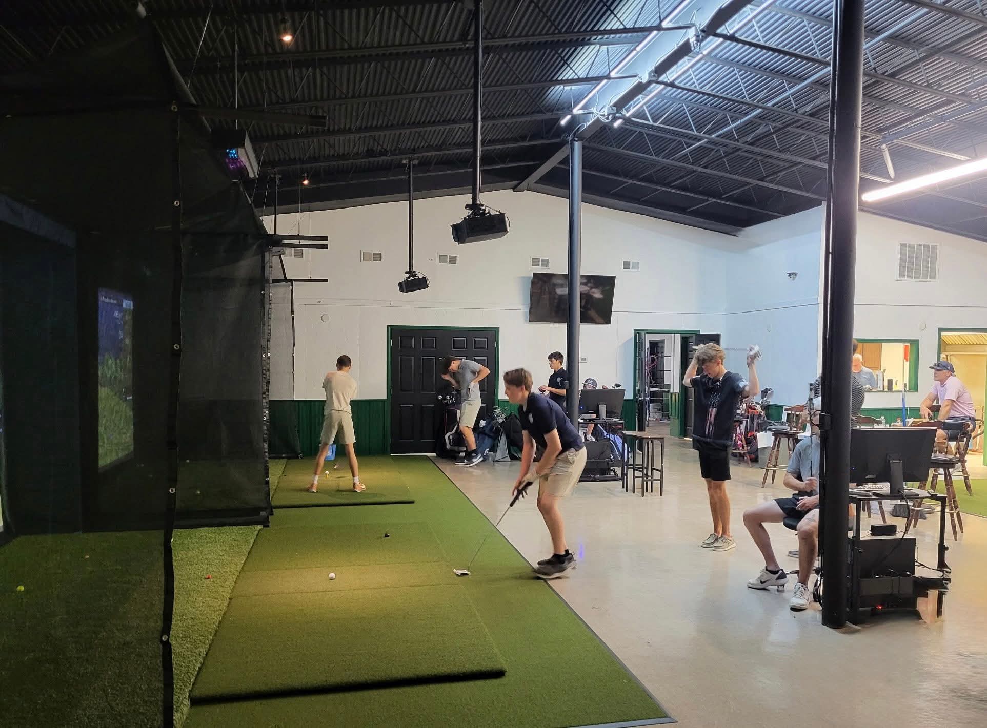 Golfers playing on indoor simulator bays at Post 42 Golf
