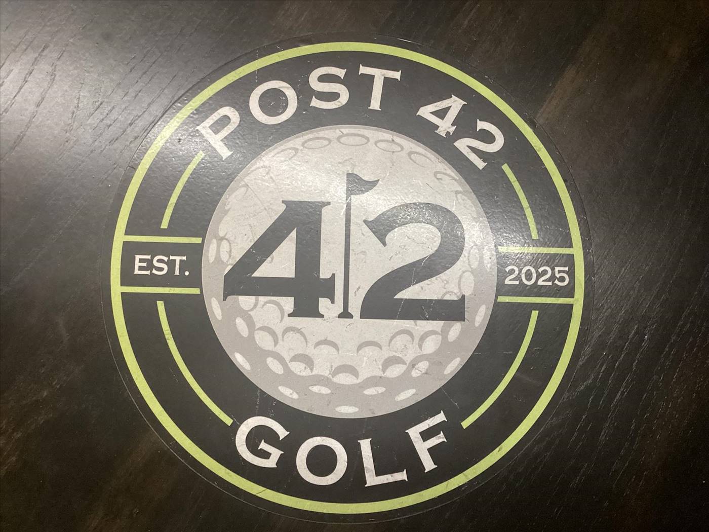 Post 42 Golf Est 2025 logo emblem on table surface